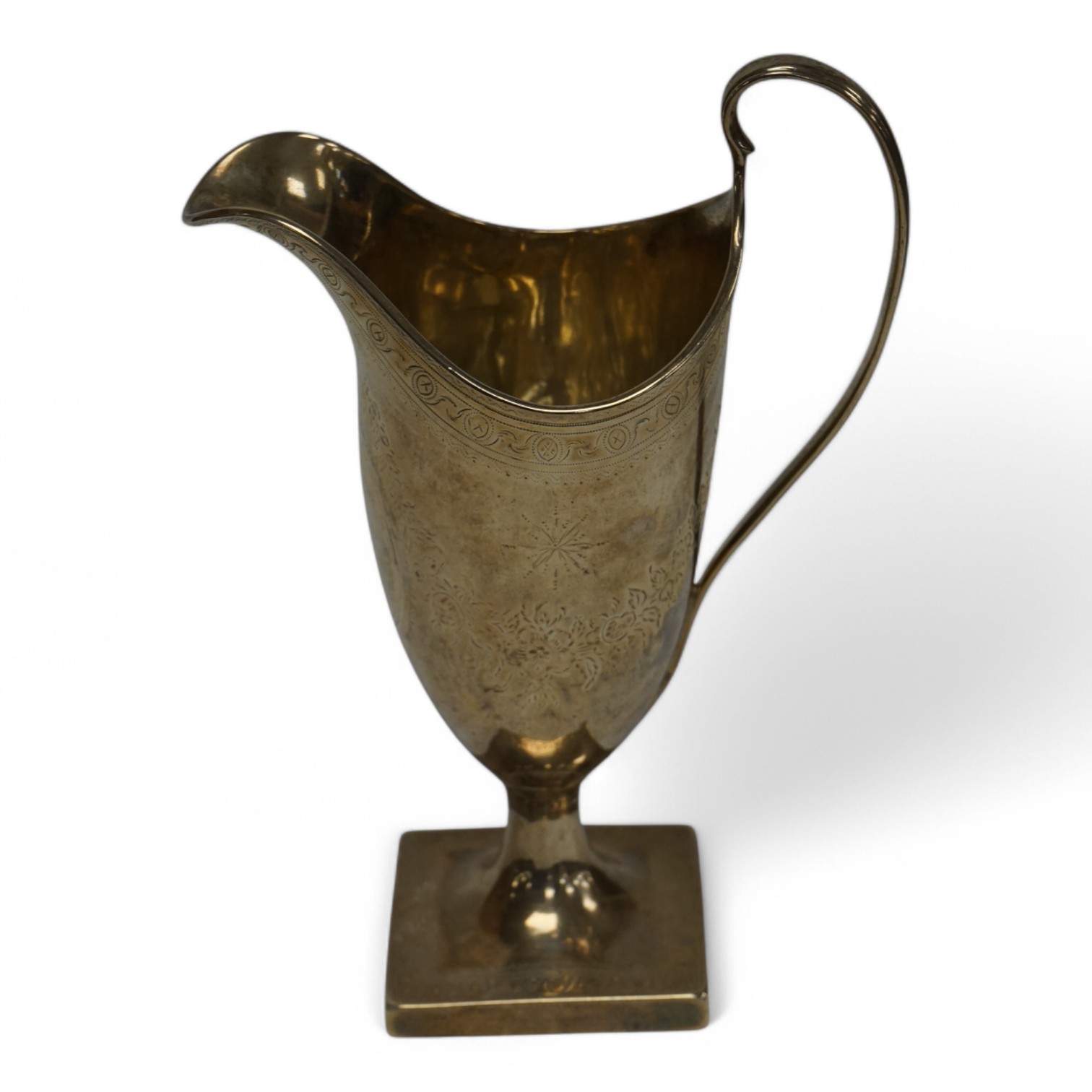 A George III engraved silver helmet shaped cream jug, with engraved armorial, on square foot, indistinct makers mark, London, 1788, 16cm, 4.5oz. Condition - fair